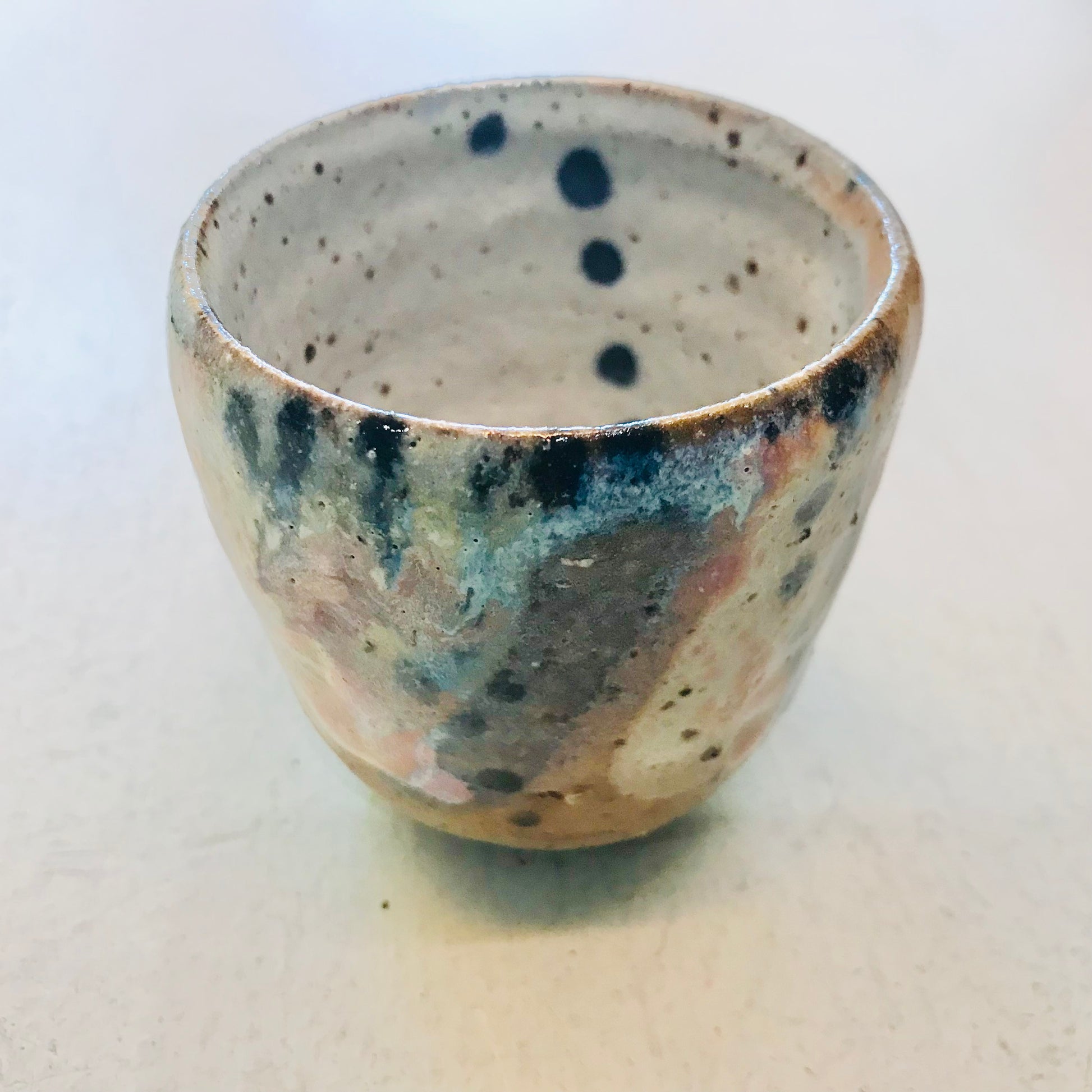 Speckled ceramic cup on a white background