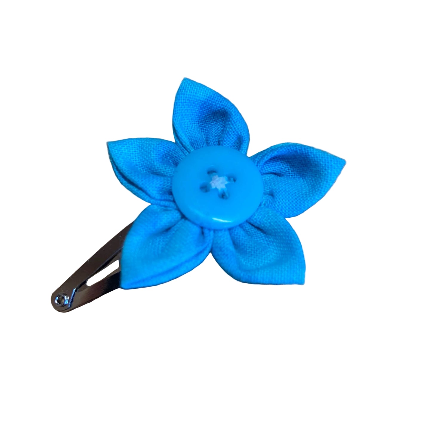 Blue flower-shaped hair clip on a wooden surface