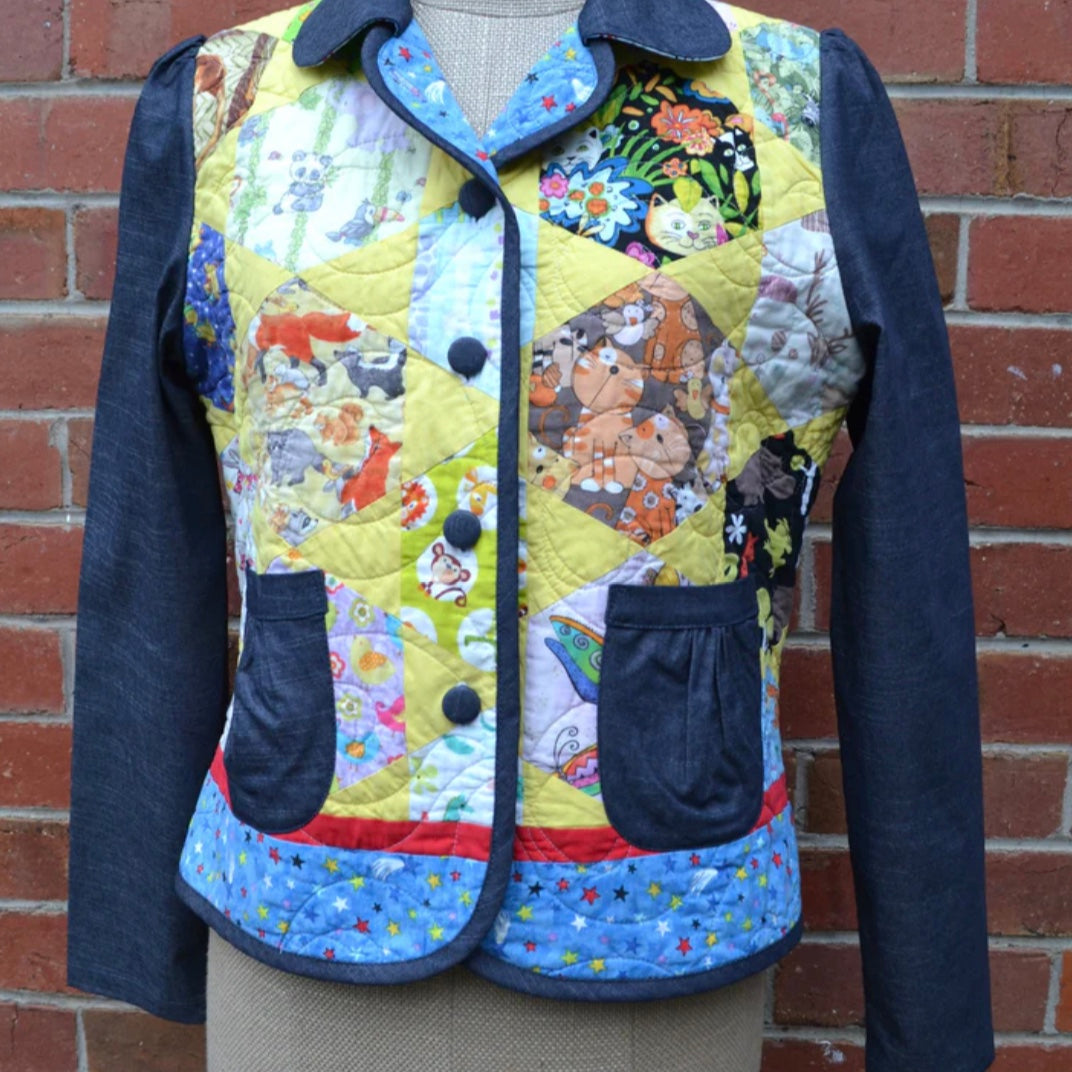 Colorful quilted jacket with animal patterns on a mannequin against a brick wall.