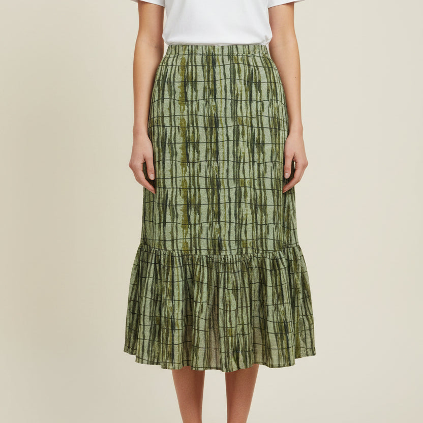 A green tiered skirt with a vertical striped batik pattern on a model
