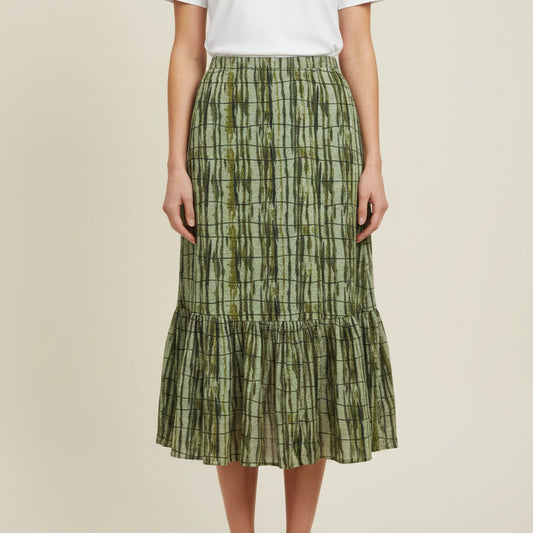A green tiered skirt with a vertical striped batik pattern on a model