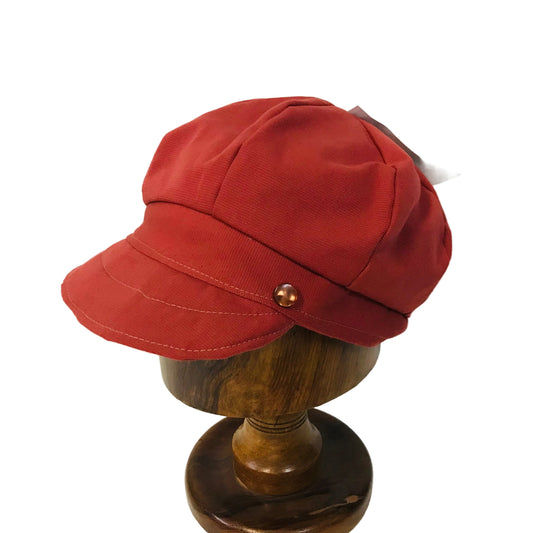 Red cap on a wooden mannequin head against a white background