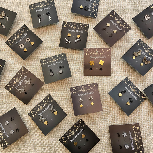 Collection of earrings on branded display cards on a light surface