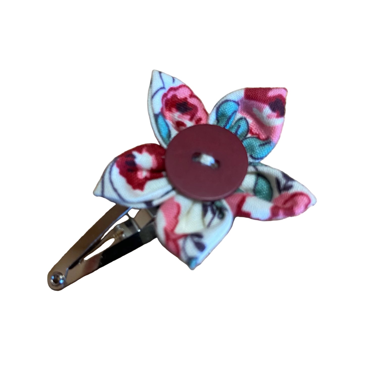 Floral fabric flower with a button center on a wooden surface
