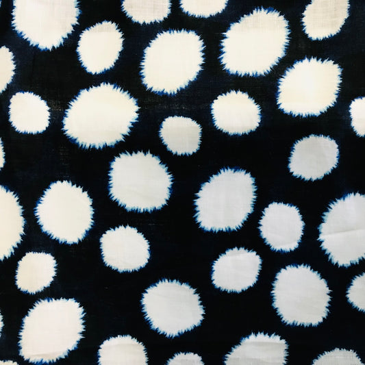 Pattern of blurred tye die white polka dots on a navy linen background