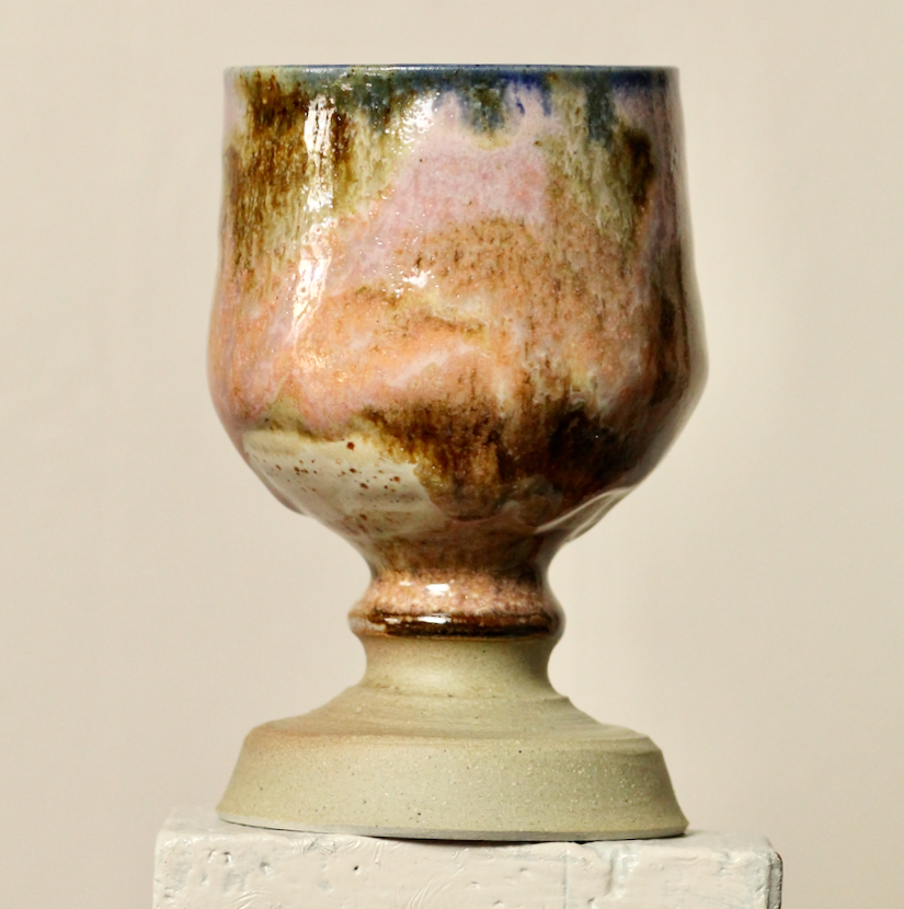 Stoneware goblet with a textured surface on a beige background