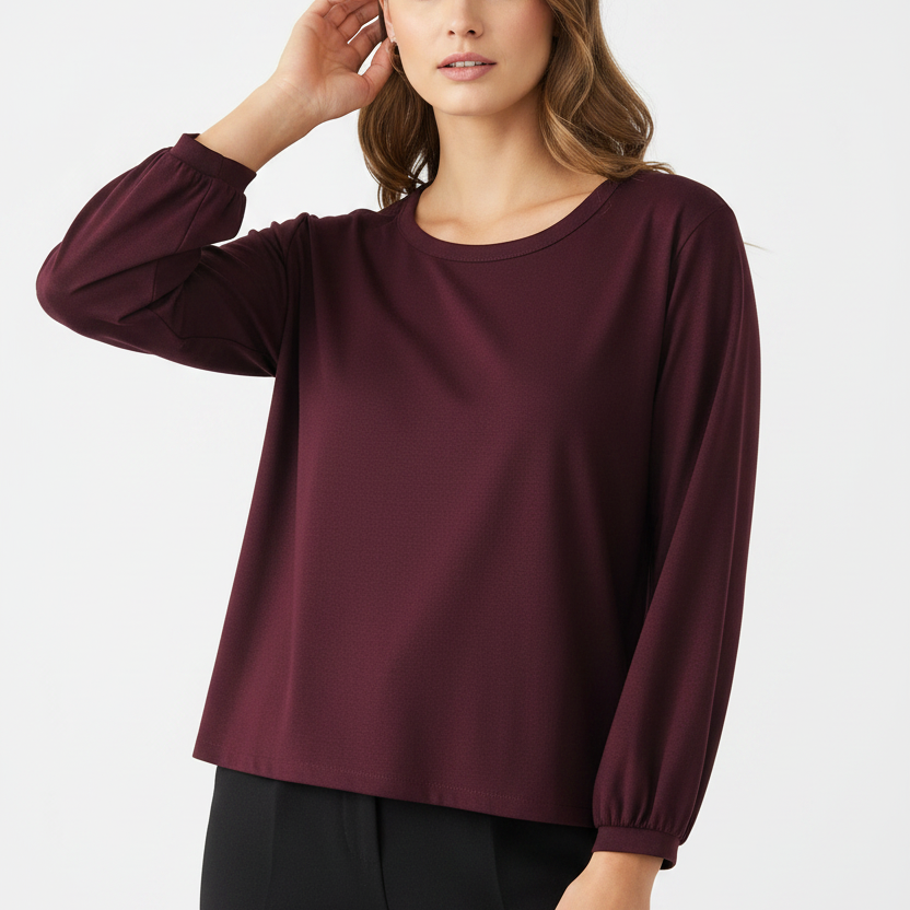 Woman wearing a burgundy long-sleeve top on a white background