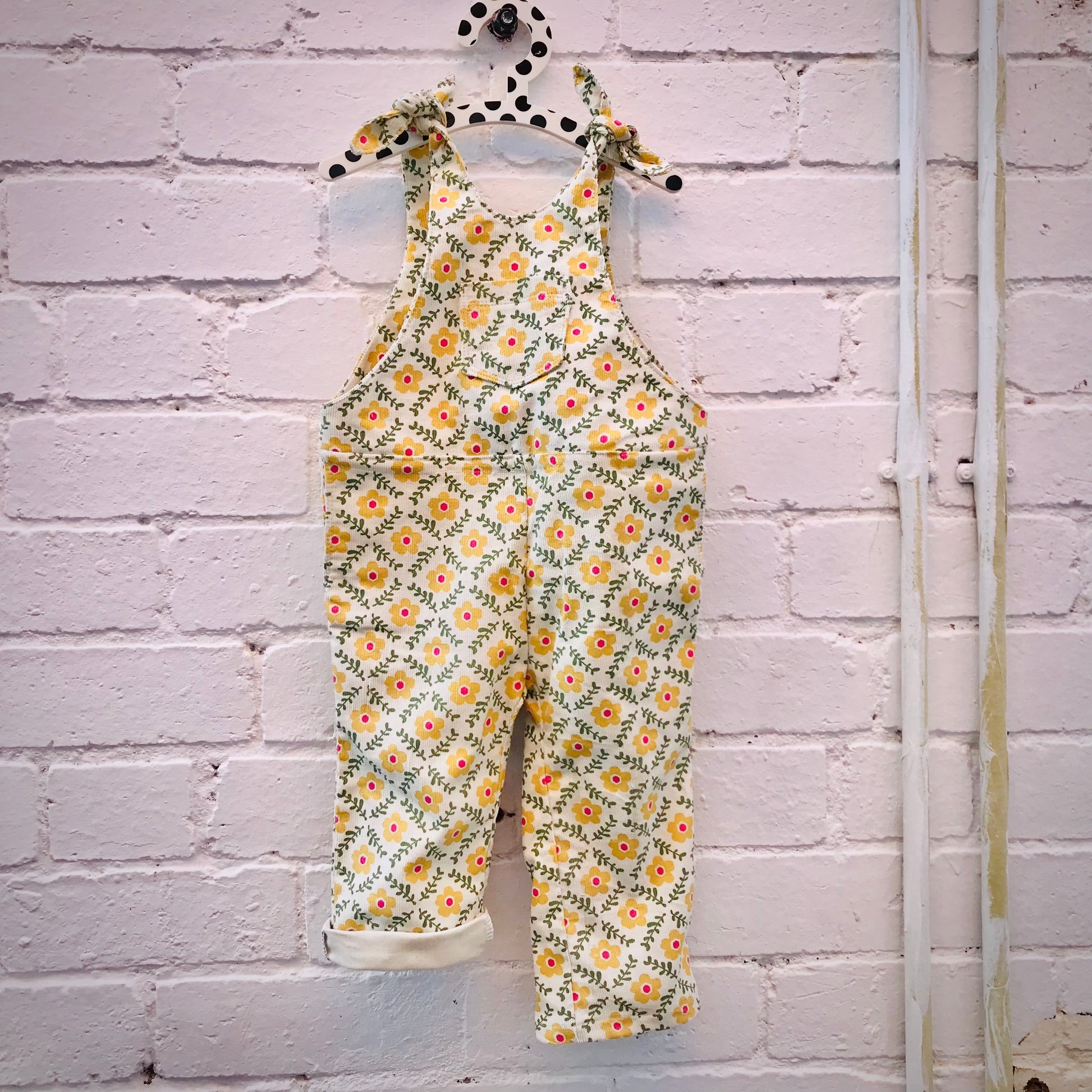 kids overalls with tie shoulders and yellow flower print, made of pinwale cord