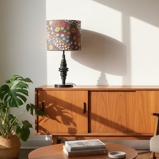 Wooden sideboard with a colorful lamp and books in a sunlit room
