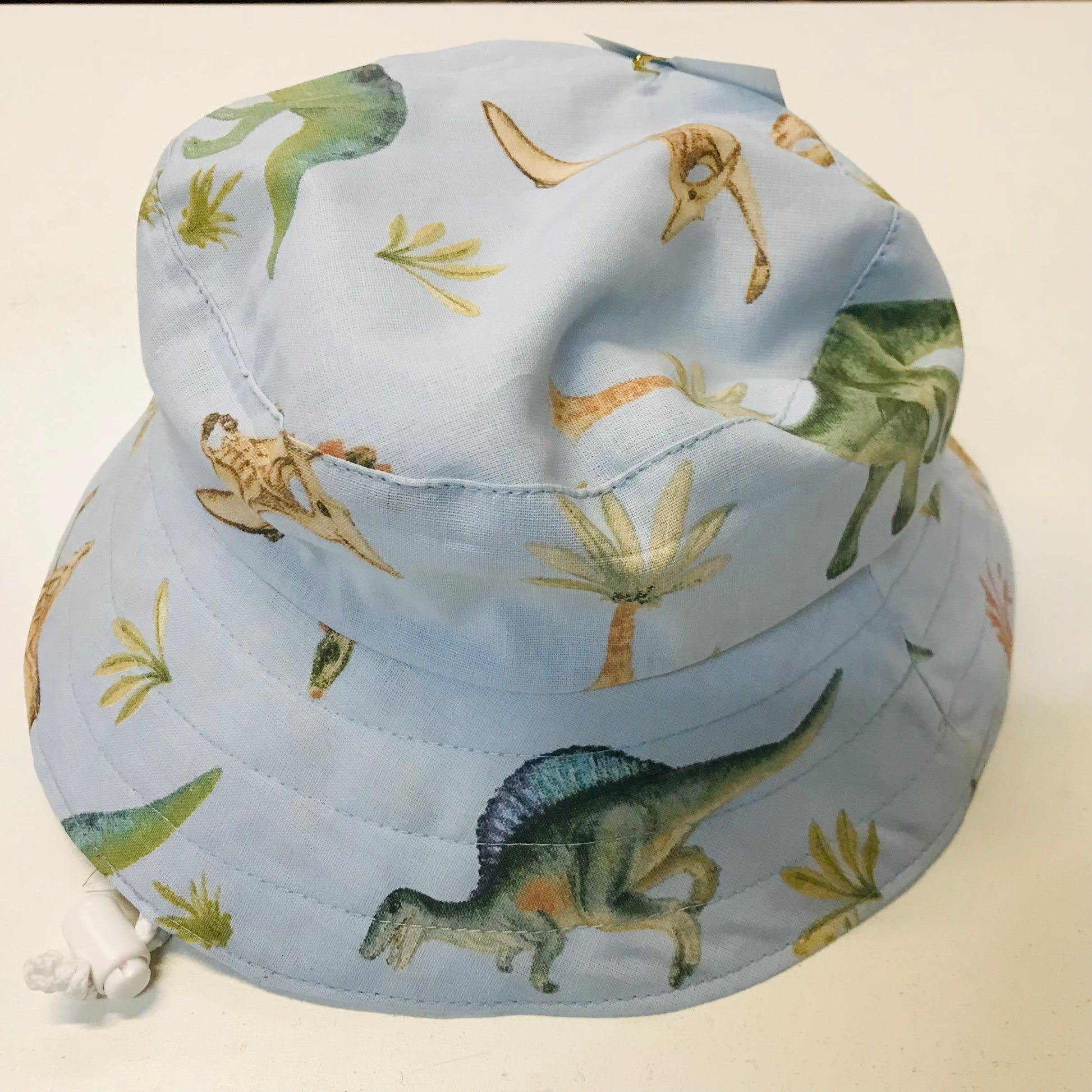Bucket hat with dinosaur pattern on a light background