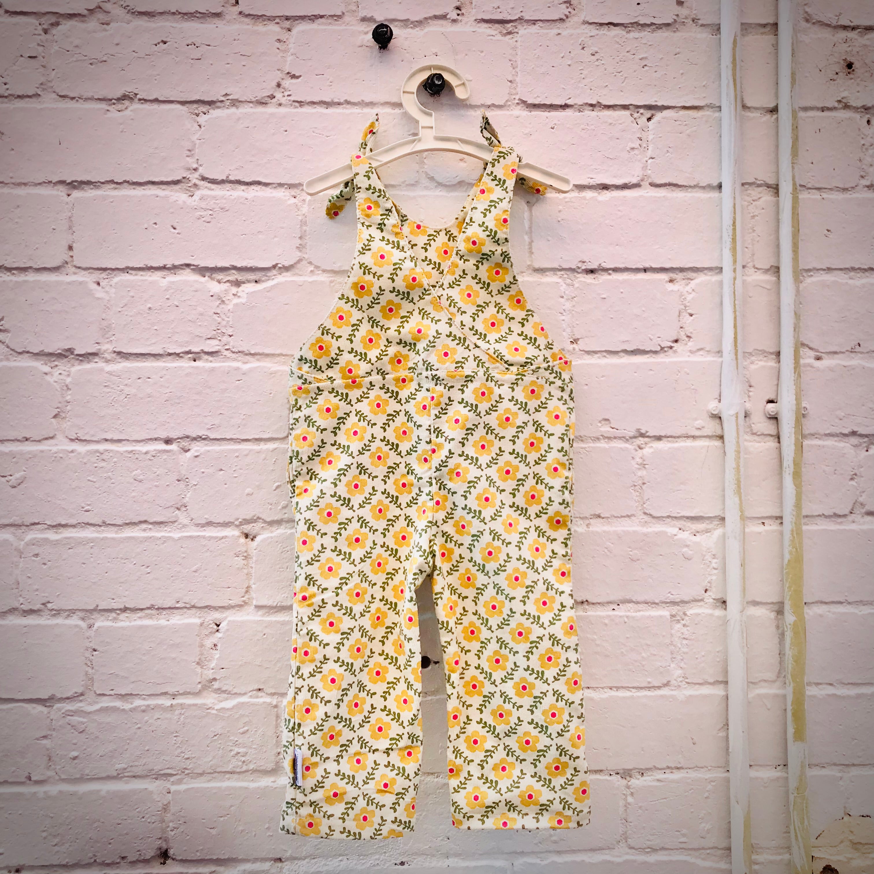 kids overalls with tie shoulders and yellow flower print, made of pinwale cord