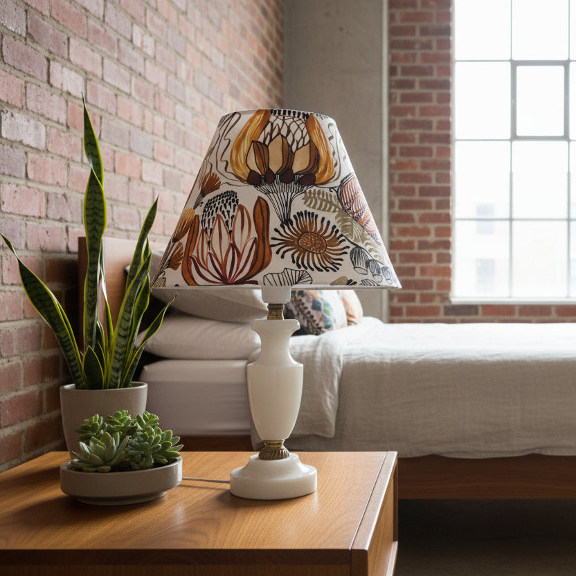 Lamp with a patterned shade on a white base against a plain background