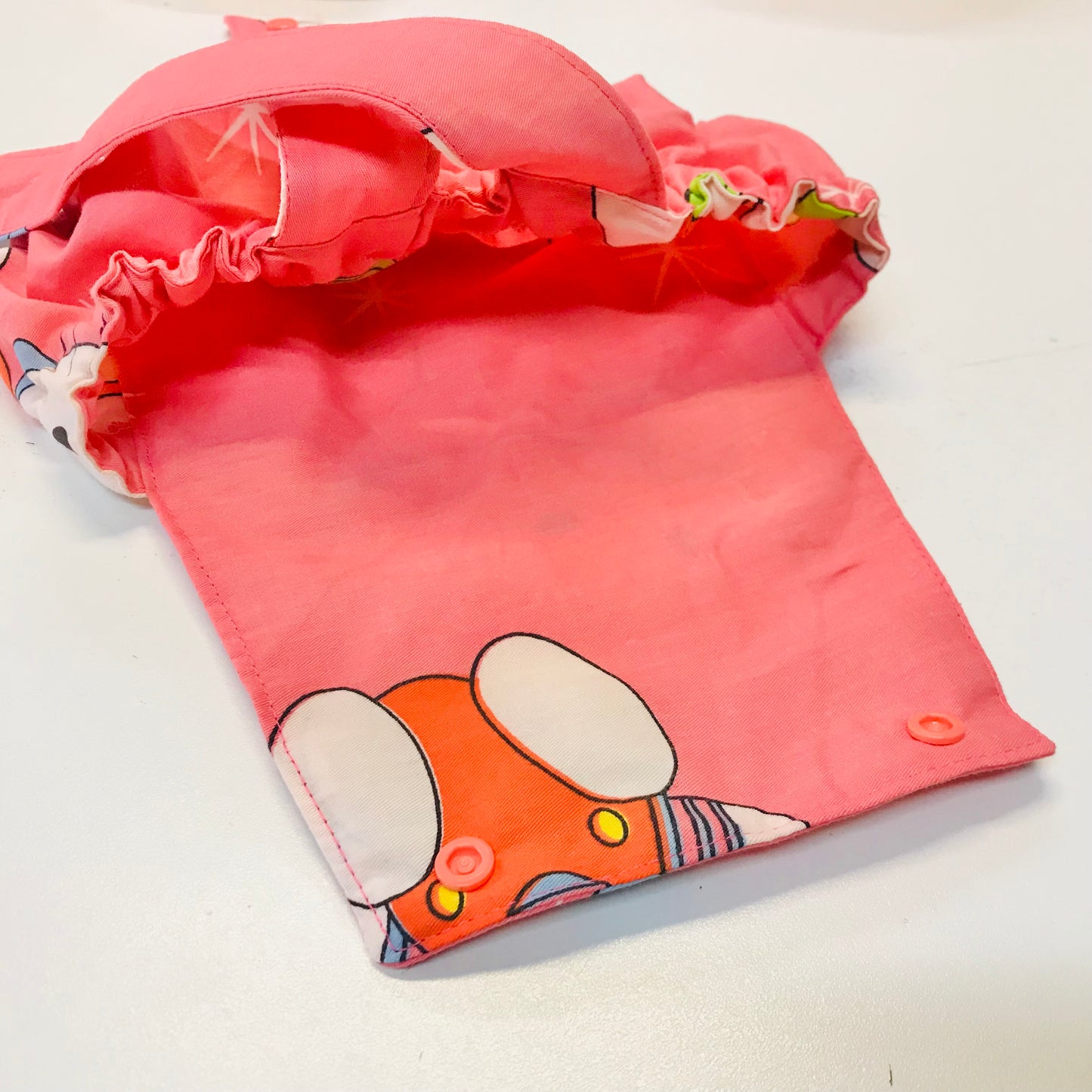 Pink summer baby romper with cartoon character design showing lining inside