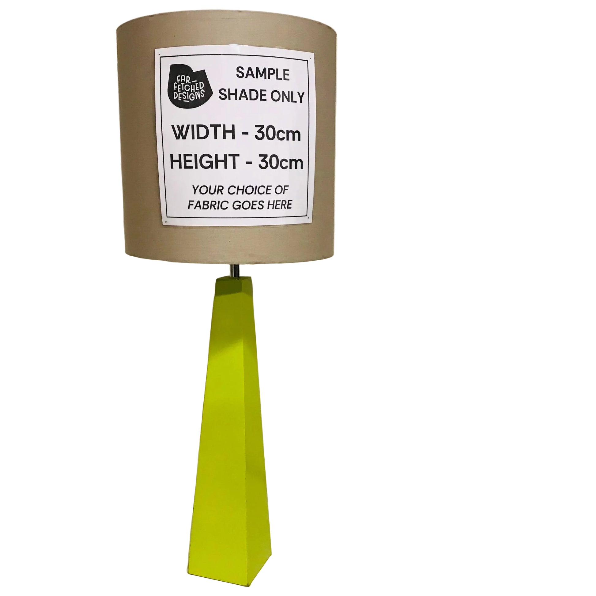 A table lamp sample with a brown fabric shade, a bright yellow-green geometric base, and a white paper label that reads 'SAMPLE SHADE ONLY' with width and height measurements, photographed against an off-white wall.