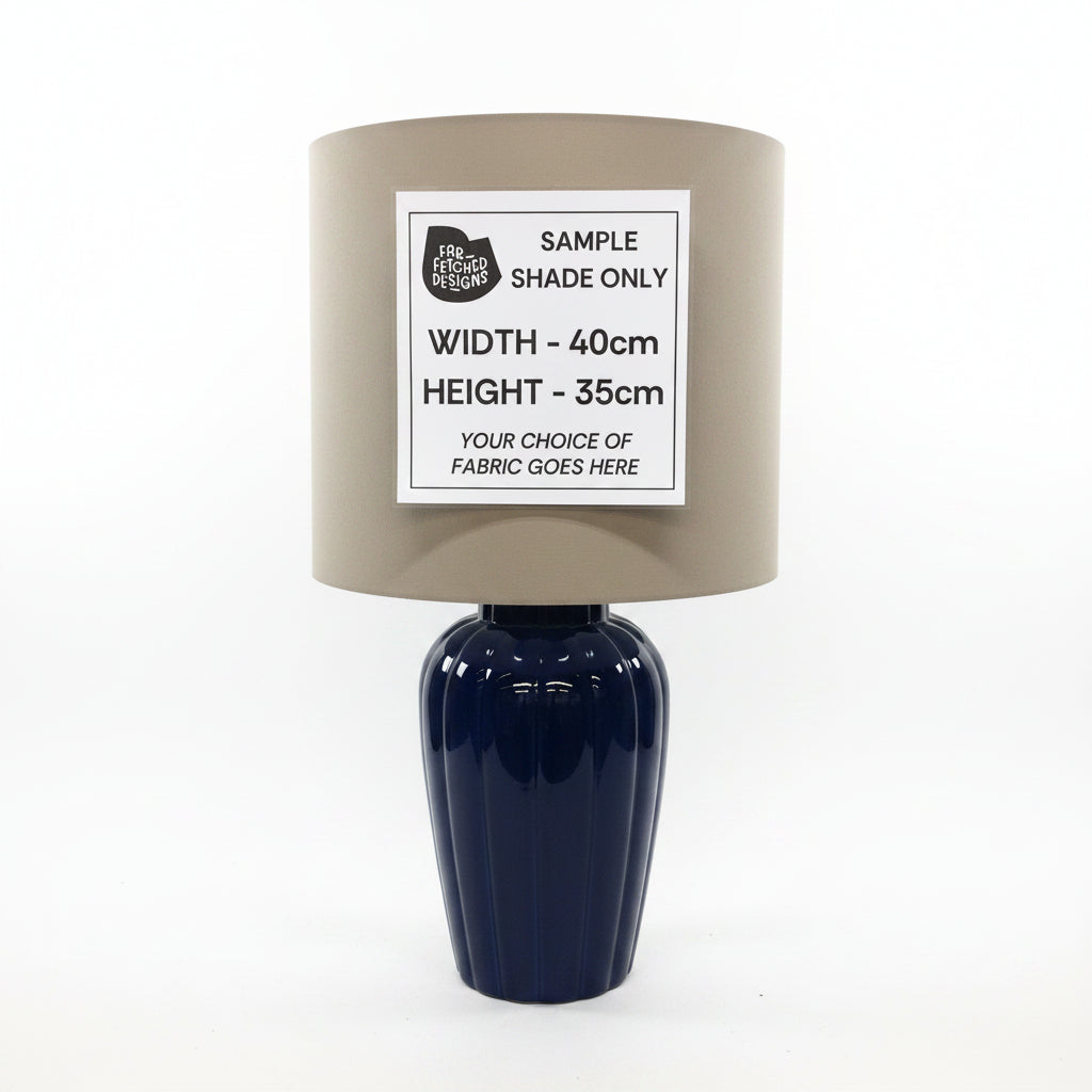 Gray lampshade with a sample size label on a blue vase against a neutral background
