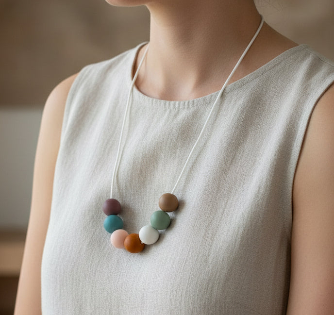 Necklace with multicolored beads on a beige surface