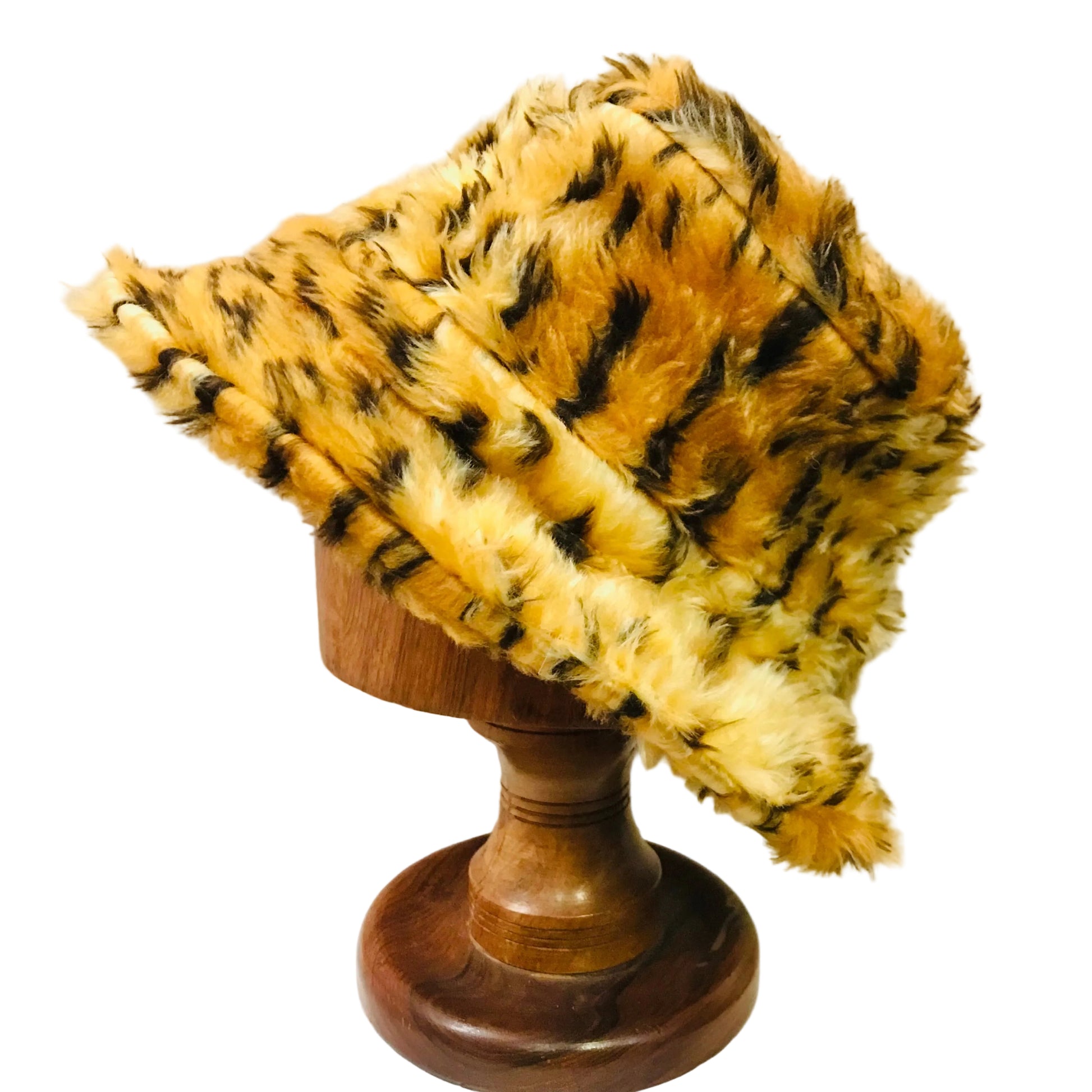 Furry yellow and black hat on a wooden mannequin head against a neutral background