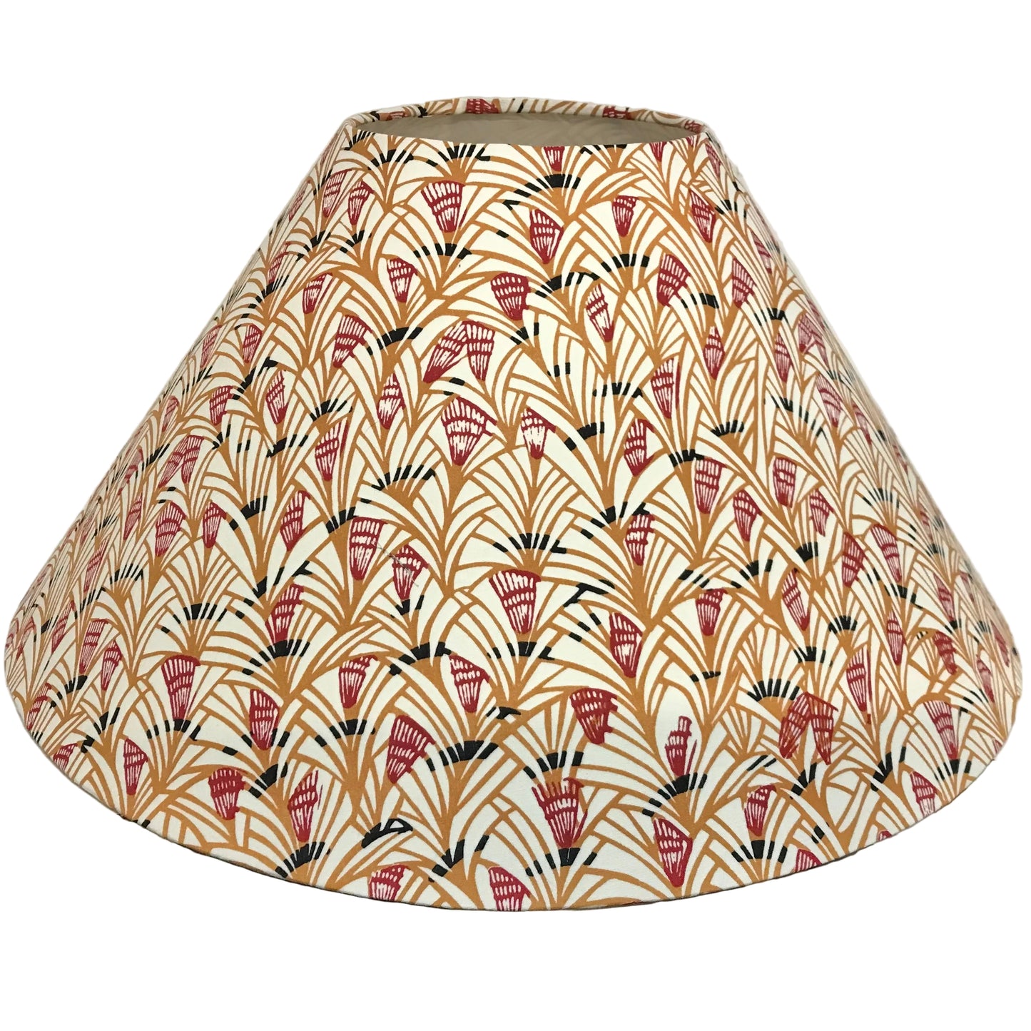 A fabric lampshade with a repeating Art Deco fan pattern in terracotta red, mustard yellow, and black on a cream background, photographed indoors against a plain light wall.