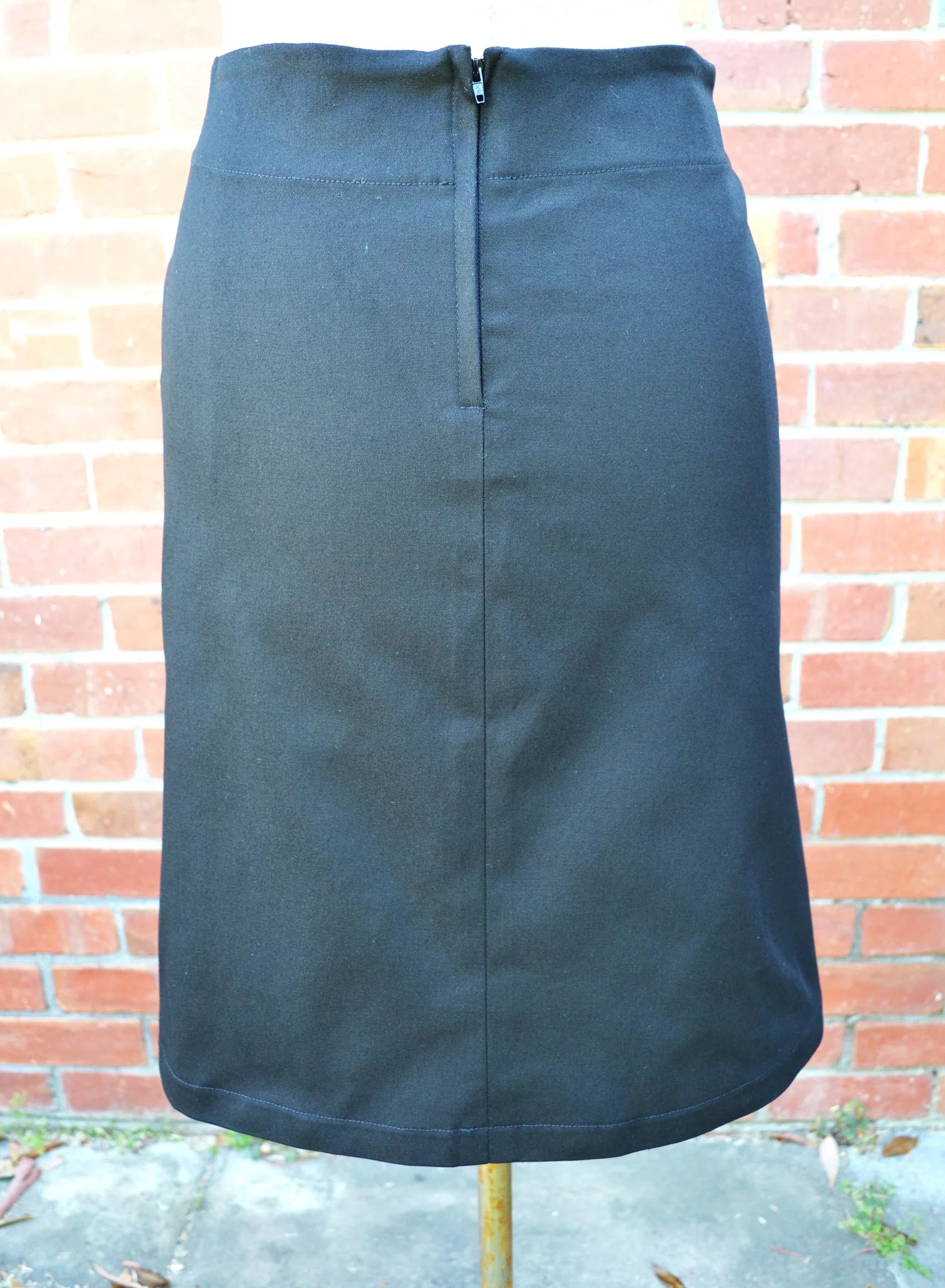 Black skirt against a brick wall