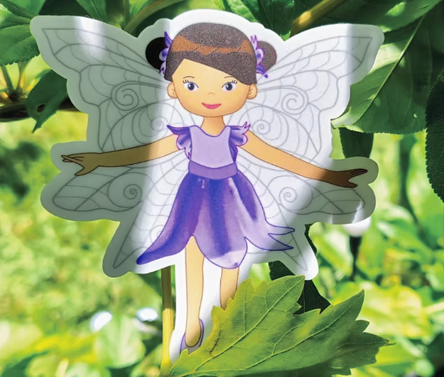 Fairy figure with purple dress and white wings on green leaves