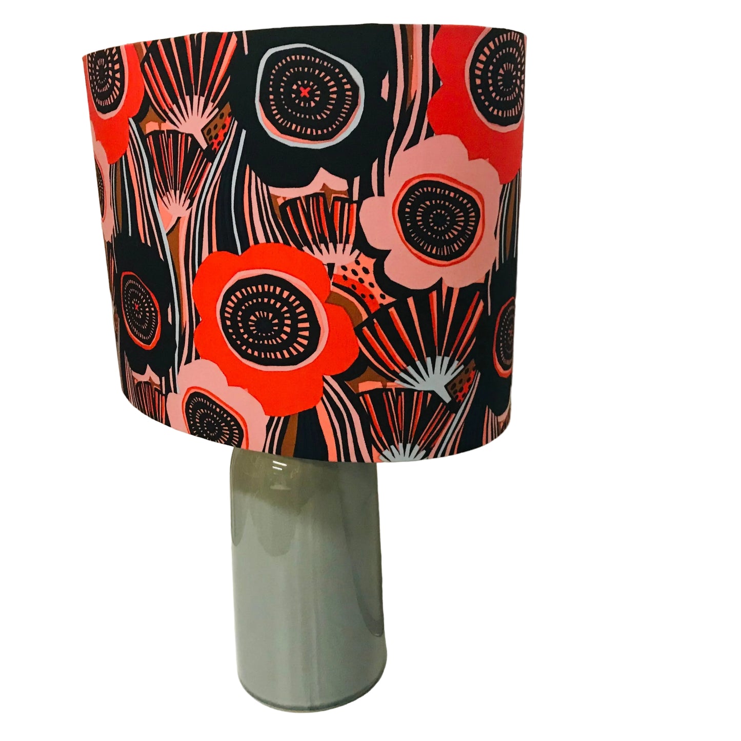 Lamp with a colorful floral patterned shade on a white surface.