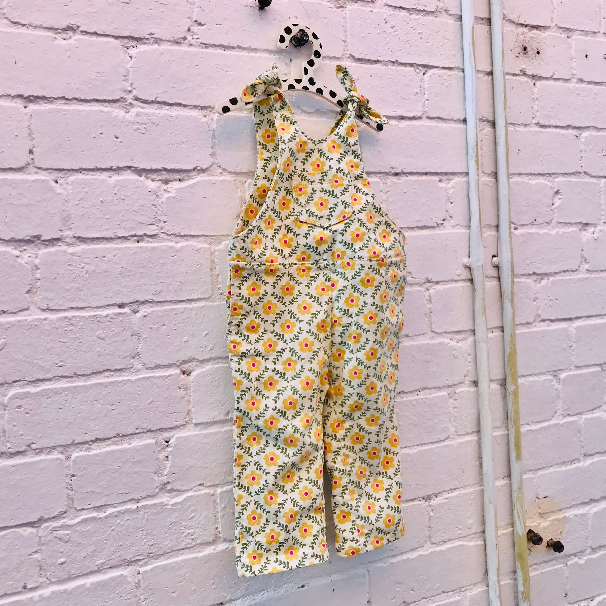 kids overalls with tie shoulders and yellow flower print, made of pinwale cord