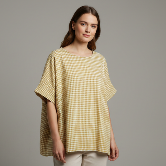 Yellow and green checkered shirt on a hanger against a textured wall.