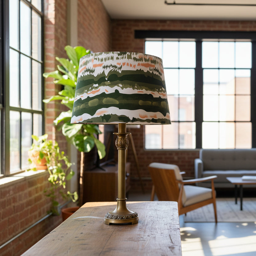 Table lamp with a decorative green and white striped shade on a plain background