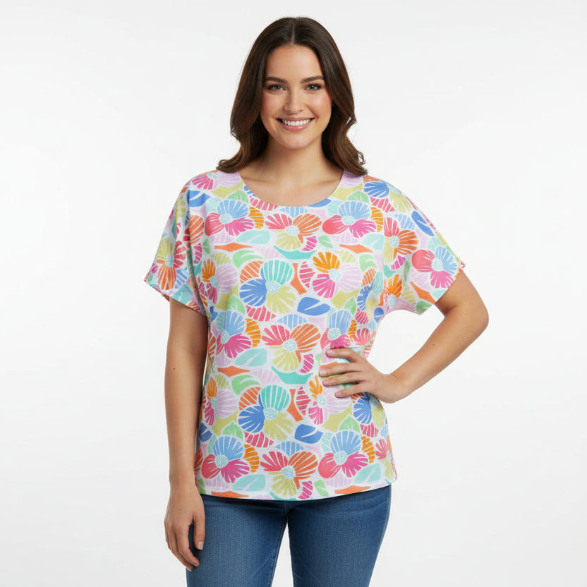 Colorful floral-patterned shirt on a mannequin against a brick wall.