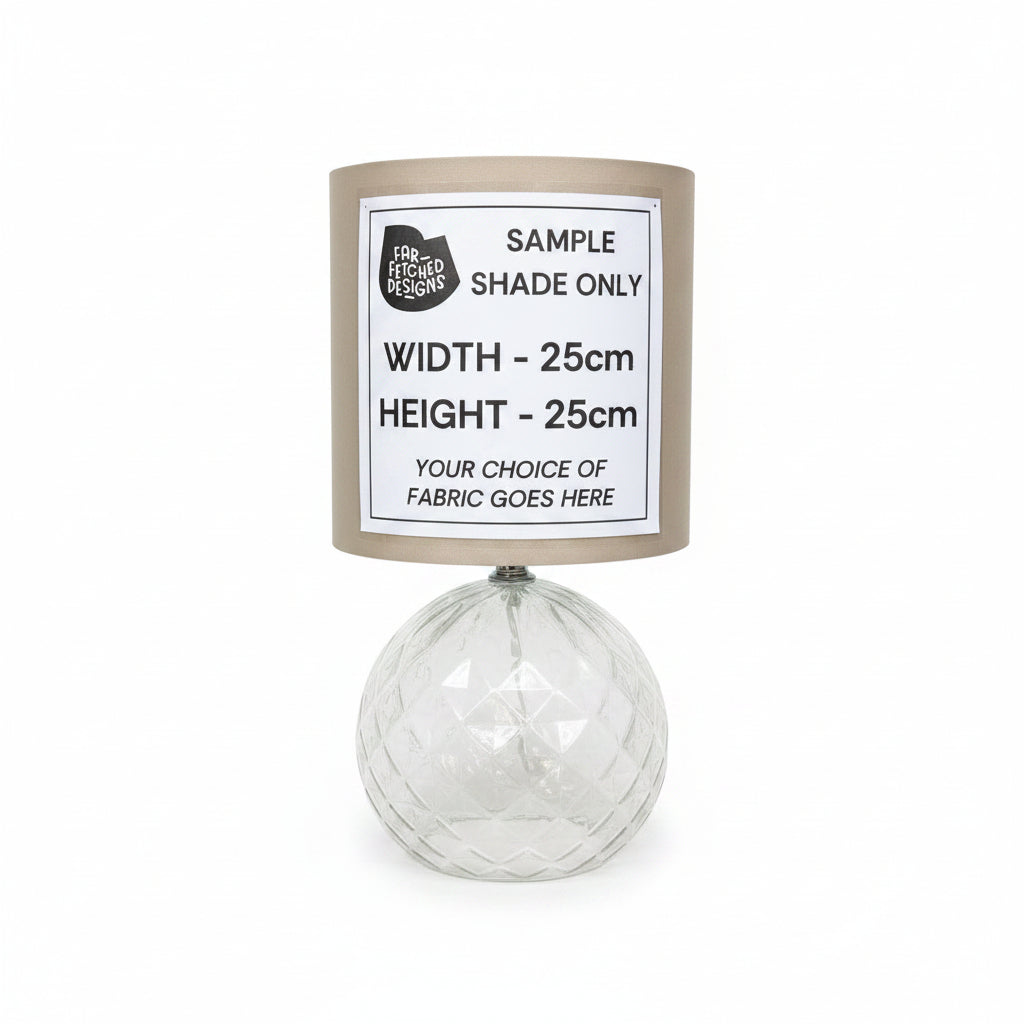 Lampshade with a label indicating sample dimensions and fabric choice on a white background