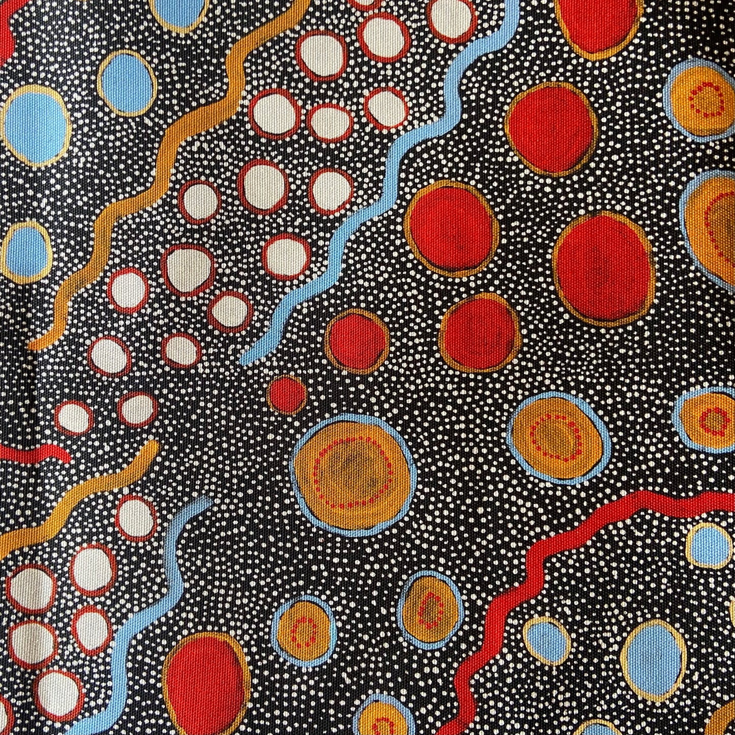 Colorful abstract pattern with red, blue, and orange shapes on a black background