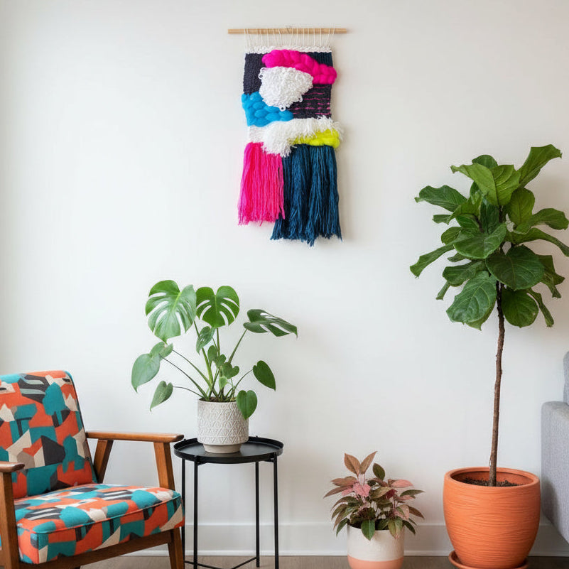 Living room with colorful armchair, plants, and wall art.