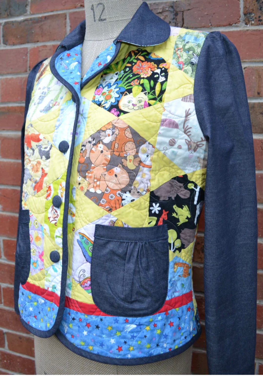 Quilted jacket with colorful patchwork design on a mannequin against a brick wall.