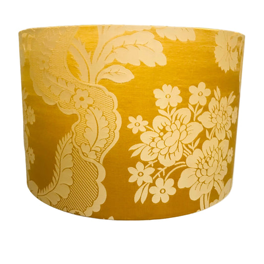 Yellow gold floral patterned lampshade on a white background