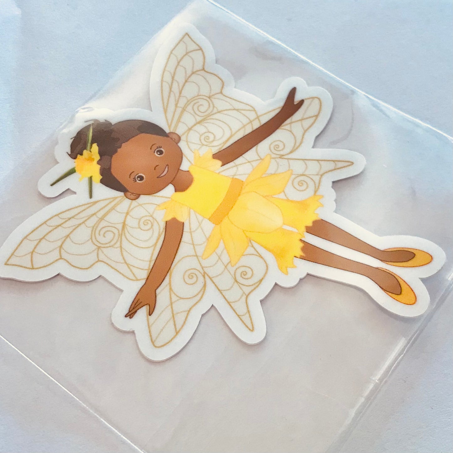 Sticker of a fairy with yellow dress and wings on a clear background