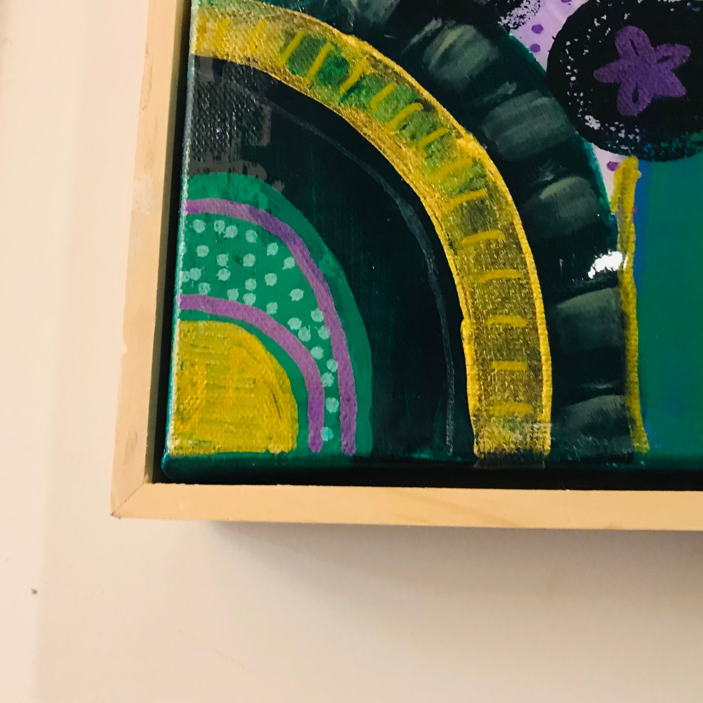 Framed abstract art with colorful patterns on a beige background