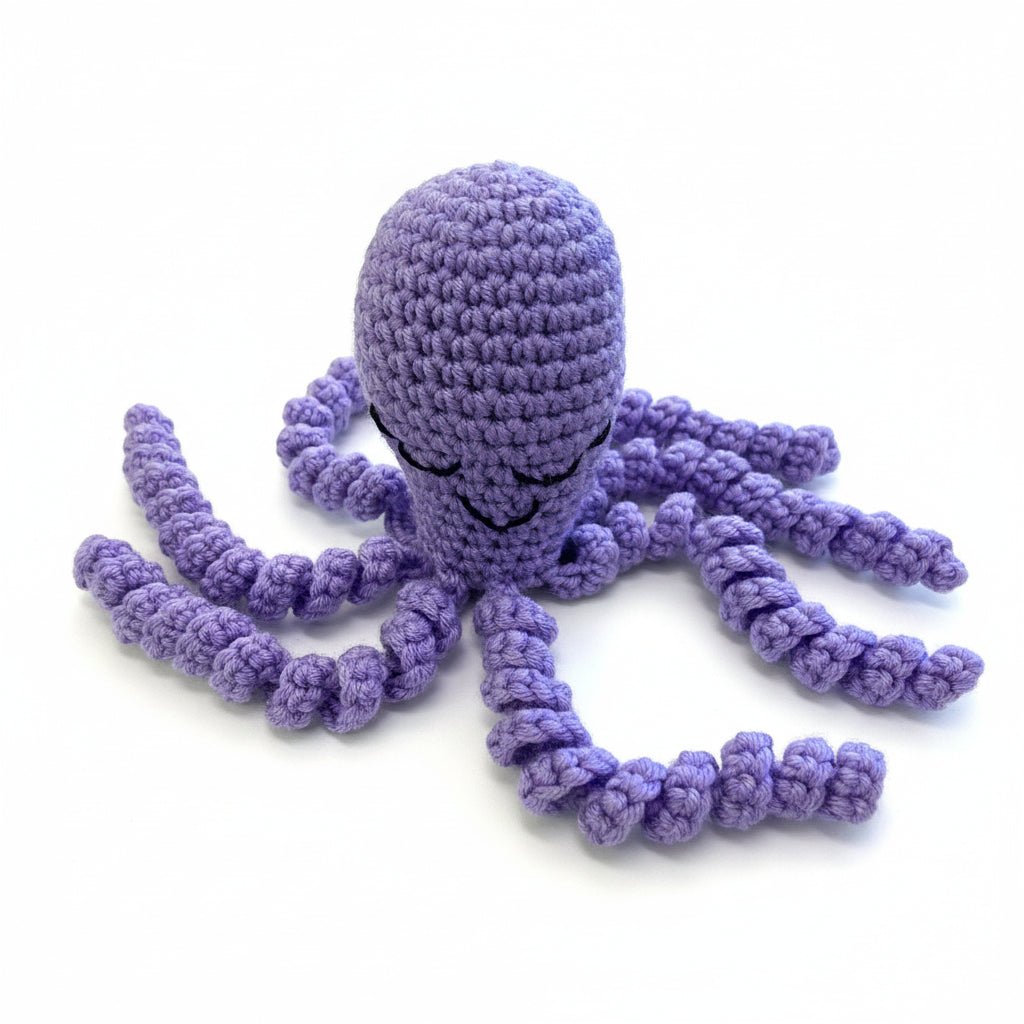 Purple crocheted octopus toy on a wooden surface