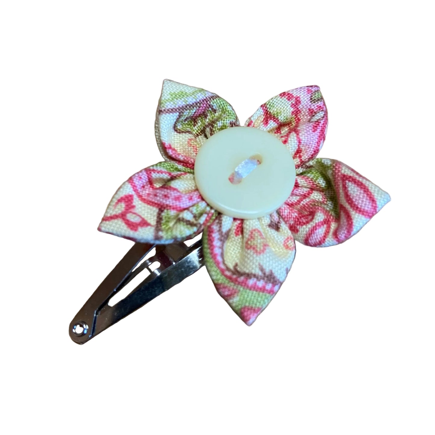 Floral fabric hair clip with a button center on a wooden surface