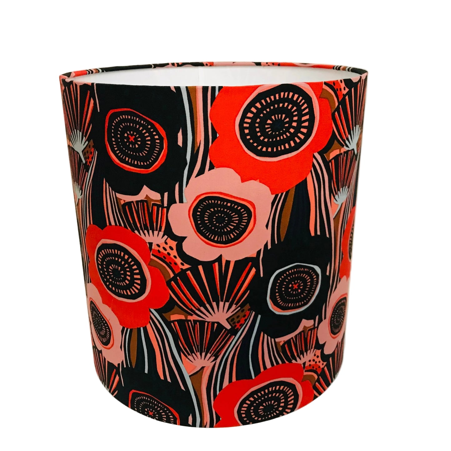 A cylindrical lampshade featuring a bold, retro floral pattern with red, pink, black, and white stylized flowers and circular details, set against a plain white background.
