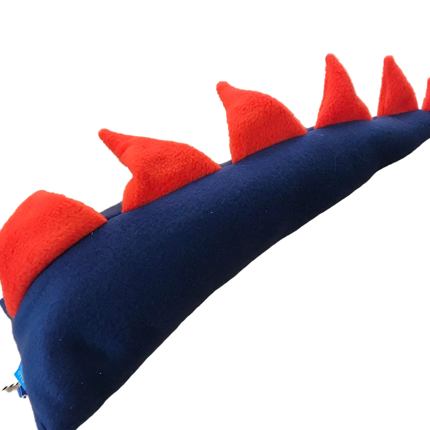 A handmade felt dinosaur tail, featuring a dark navy blue body and bright red spikes, shown on a light wood background.