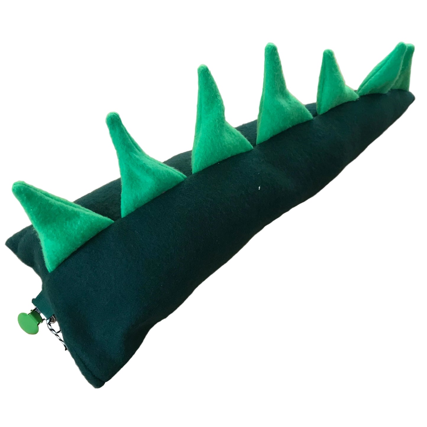 A dark green felt dinosaur tail, featuring bright green felt spikes along the top edge, shown on a light wood background.