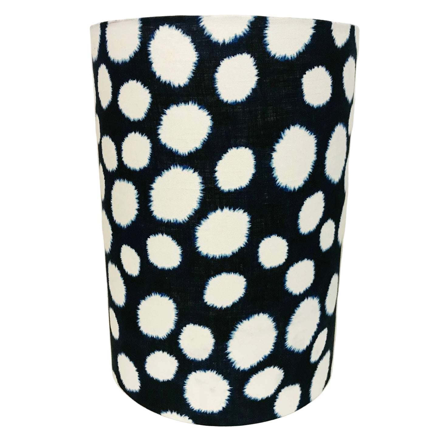 Black cylindrical lampshade with white polka dot pattern on a navy background