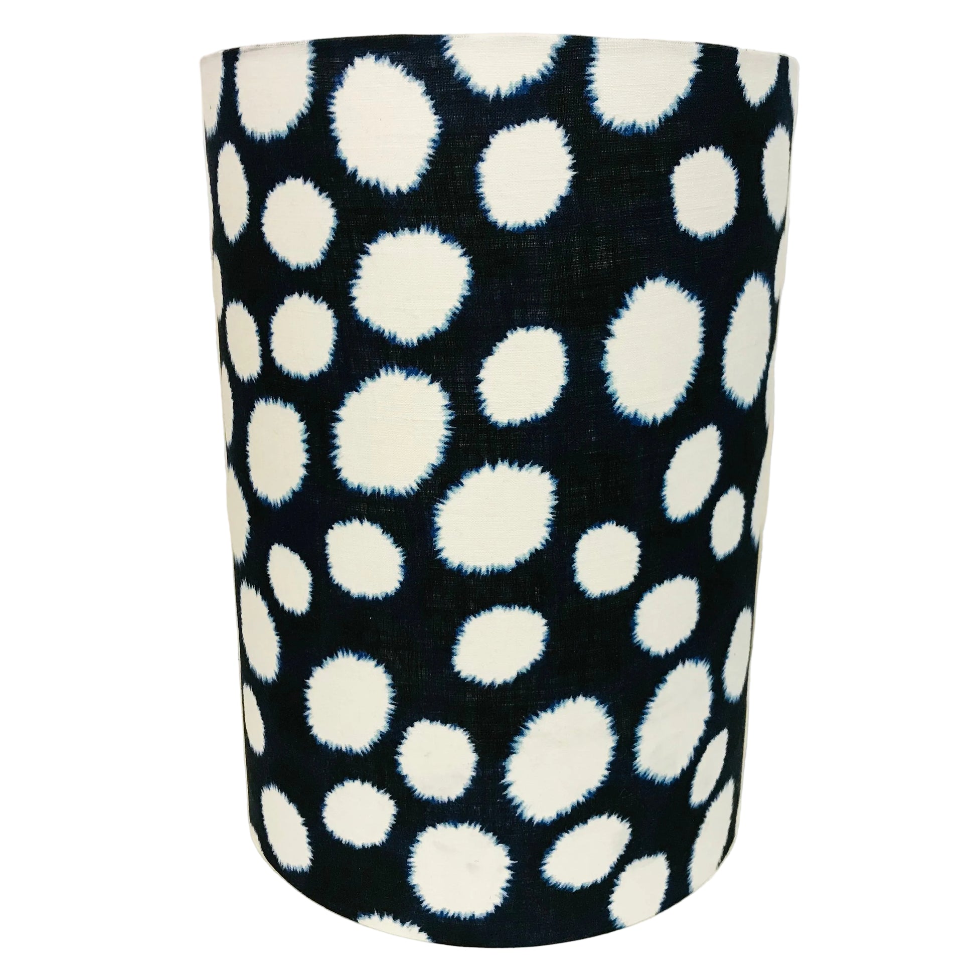 Black cylindrical lampshade with white polka dot pattern on a navy background