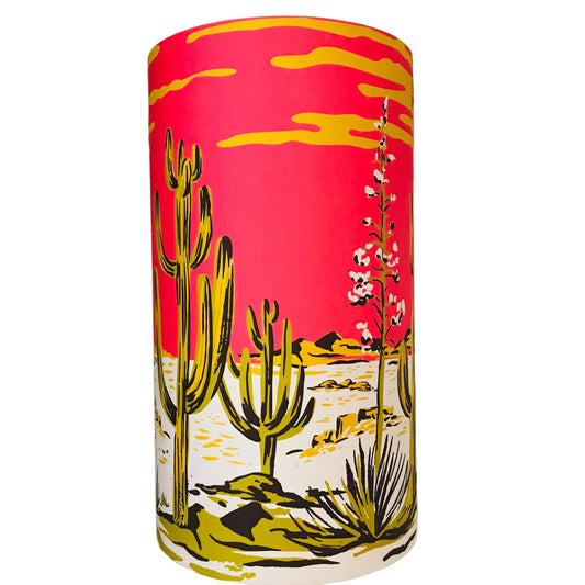 Cylindrical tall lamp shade with desert landscape design featuring cacti and flowers on a pink background.
