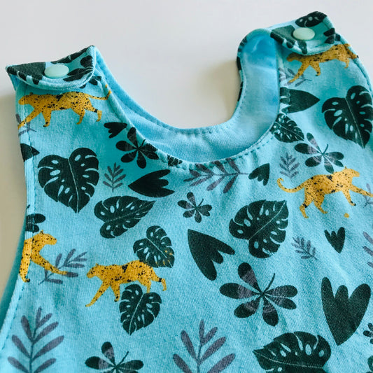 Children's sleeveless top with jungle leaf and animal pattern on a light blue background