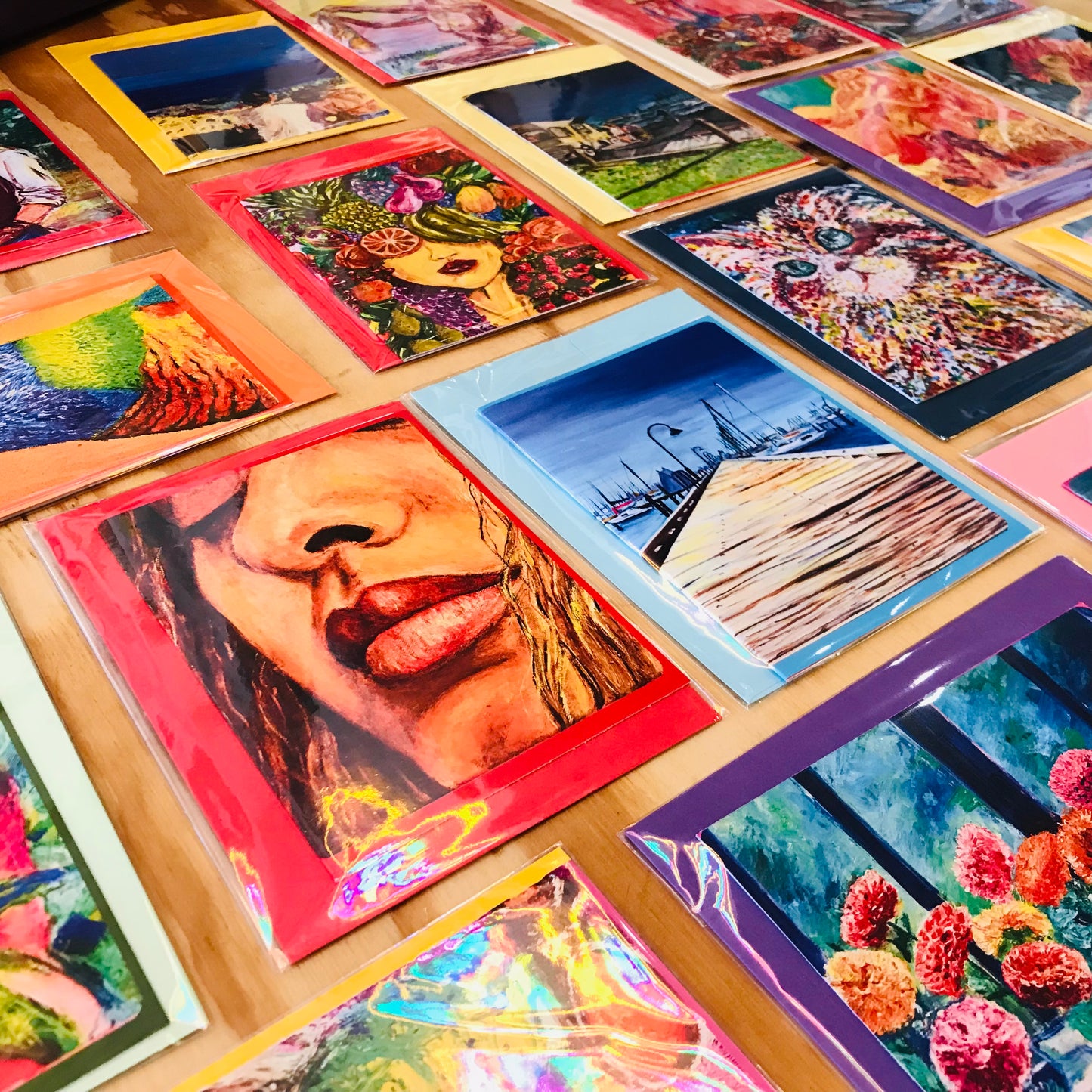 Collection of colorful art prints on a wooden surface