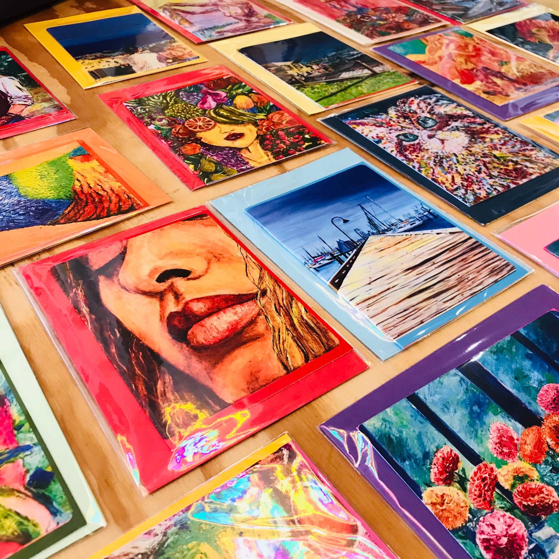 Collection of colorful art prints on a wooden surface