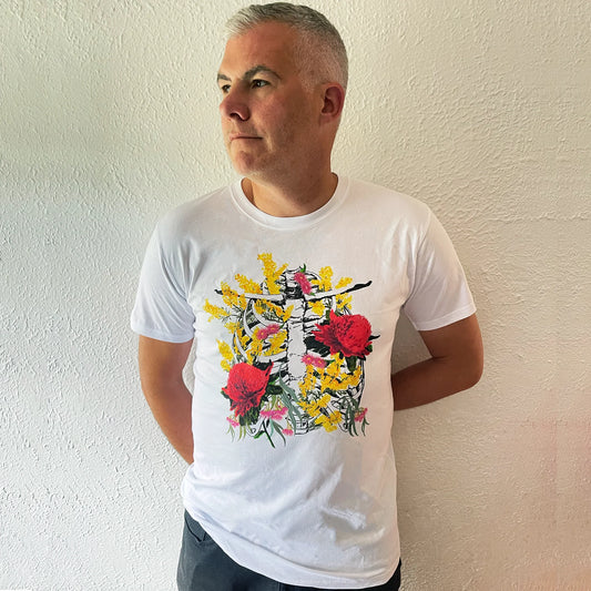 Man wearing a white t-shirt with floral design against a plain wall