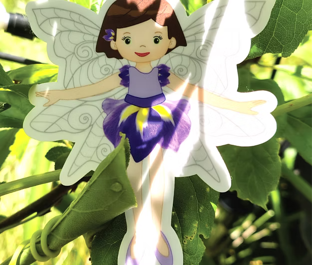 Illustration of a fairy with purple dress and white wings on green leaves