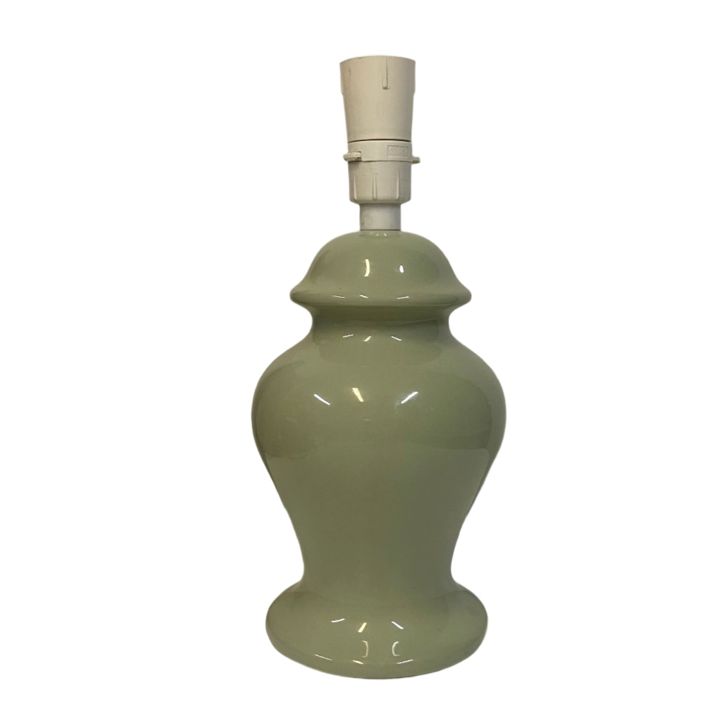 Green ceramic lamp on a white surface with a plain background